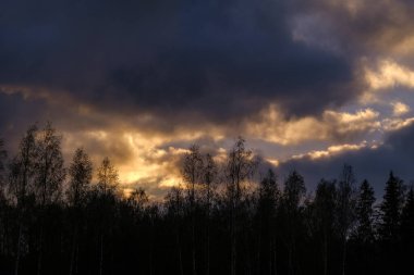 Tarlaların ve şehirlerin üzerinde dramatik, kırmızı, karanlık, dramatik bulutlar var.