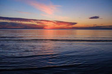 Tarlaların ve şehirlerin üzerinde dramatik, kırmızı, karanlık, dramatik bulutlar var.