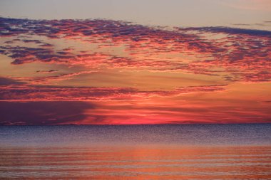 Tarlaların ve şehirlerin üzerinde dramatik, kırmızı, karanlık, dramatik bulutlar var.