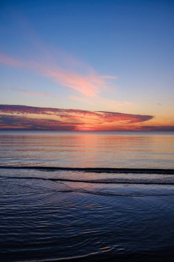 Tarlaların ve şehirlerin üzerinde dramatik, kırmızı, karanlık, dramatik bulutlar var.