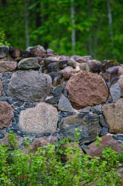 Yeşil çayır yazında taş bloktan arta kalanlar. Alandaki harabeler