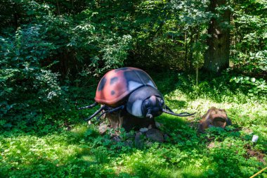 Yapay dinozorlar ve parktaki antik sürüngen heykelleri yaz yeşili ortamda