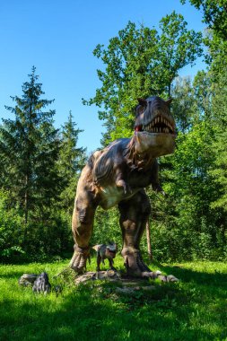 Yapay dinozorlar ve parktaki antik sürüngen heykelleri yaz yeşili ortamda