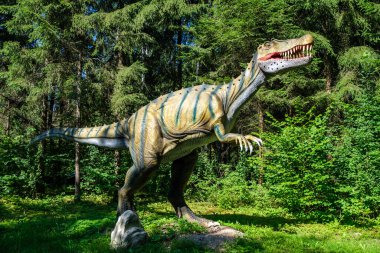 Yapay dinozorlar ve parktaki antik sürüngen heykelleri yaz yeşili ortamda