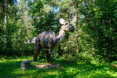 Yapay dinozorlar ve parktaki antik sürüngen heykelleri yaz yeşili ortamda