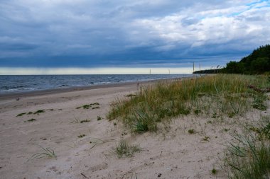 Deniz kenarındaki boş kumlu kumsalda kayalar ve mavi gökyüzü. sessiz meditasyon arkaplanı