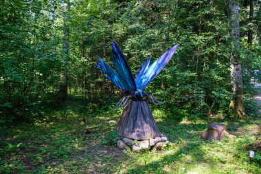 Yapay dinozorlar ve parktaki antik sürüngen heykelleri yaz yeşili ortamda