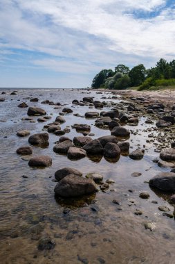 Deniz kenarındaki boş kumlu kumsalda kayalar ve mavi gökyüzü. sessiz meditasyon arkaplanı