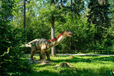 Yapay dinozorlar ve parktaki antik sürüngen heykelleri yaz yeşili ortamda