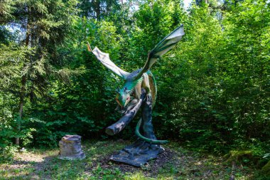 Yapay dinozorlar ve parktaki antik sürüngen heykelleri yaz yeşili ortamda