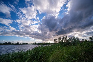 Yazın mavi suyla deniz limanı üzerinde dramatik fırtına bulutları