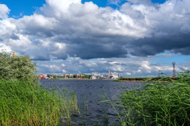 Yazın mavi suyla deniz limanı üzerinde dramatik fırtına bulutları