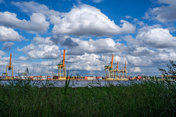dramatic storm clouds over sea port in summer with blue water