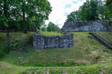 Yeşil yaz çayırındaki eski taş şatonun kalıntıları.