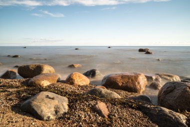 Sabahleyin kayalık bir sahil manzarası. Uzun pozlu çekim.