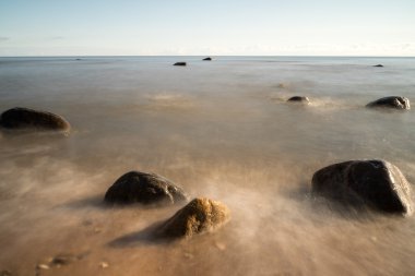 Sabahleyin kayalık bir sahil manzarası. Uzun pozlu çekim.