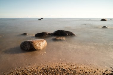 Sabahleyin kayalık bir sahil manzarası. Uzun pozlu çekim.