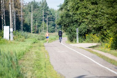 Koşu adam ve adam yolda Bisiklete binme