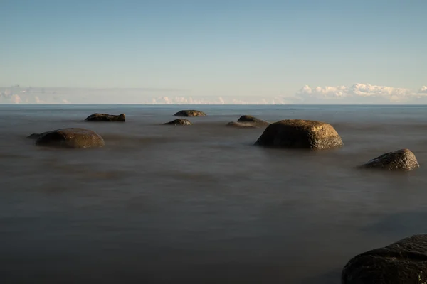 朝の岩だらけの海岸の眺め。長時間露光. — ストック写真