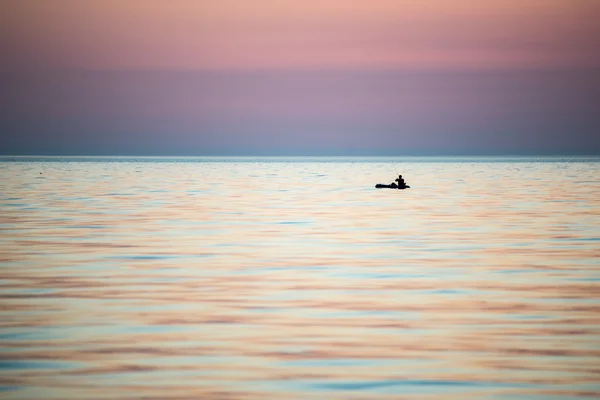 Small boat in the sea at sunrise — Stock Photo, Image