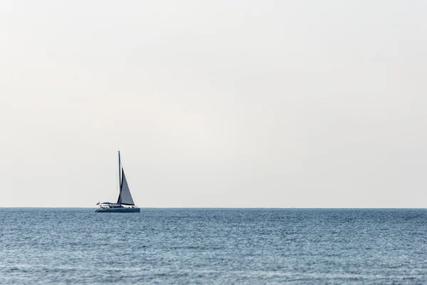 Маленький белый корабль в море — стоковое фото