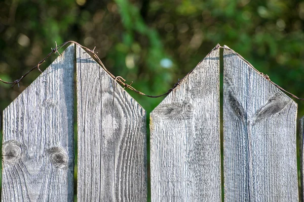 上に有刺鉄線と古い木製のフェンス — ストック写真
