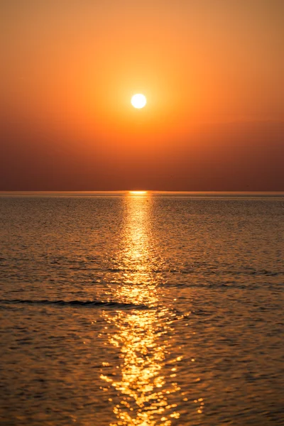 Colorido atardecer en el mar con reflejos y nubes — Foto de Stock