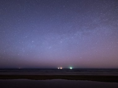 gece gökyüzünde yıldız sahilde. alan görünüm.