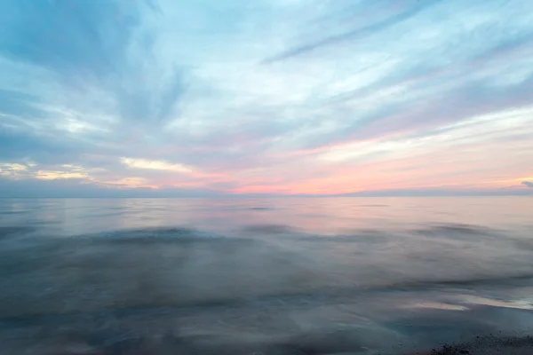Długich ekspozycji, którą dramatyczne niebieski zachód słońca z wyprane fale — Zdjęcie stockowe