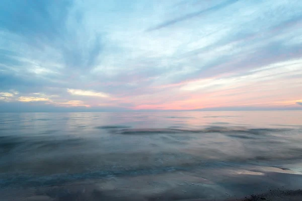 Długich ekspozycji, którą dramatyczne niebieski zachód słońca z wyprane fale — Zdjęcie stockowe