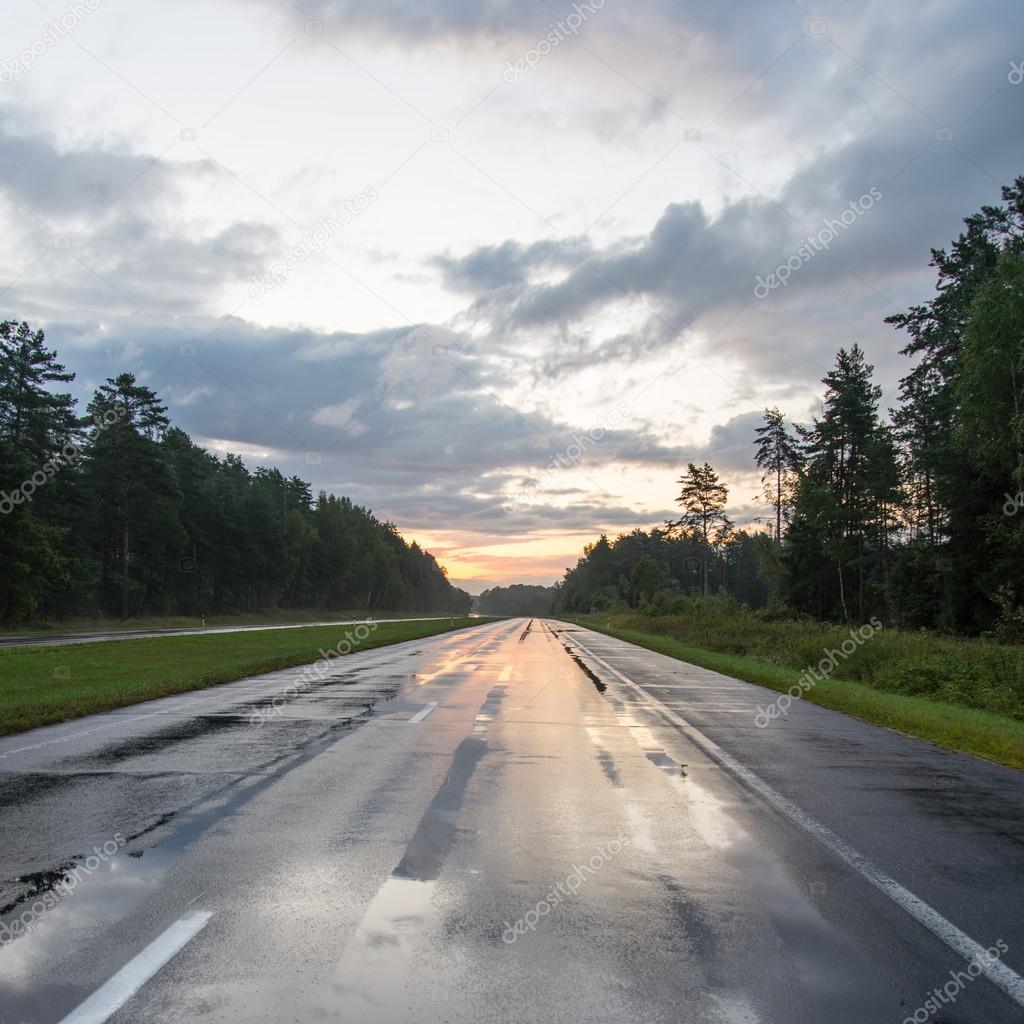 wet asphalt road with sun reflections