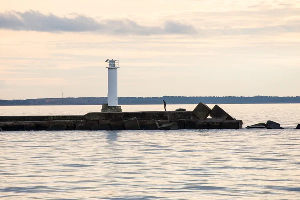 Vågbrytaren i havet med fyr på det — Stockfoto