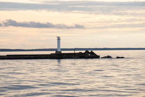 Vågbrytaren i havet med fyr på det — Stockfoto