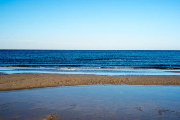 Пляж з крижаним морем з першими шматочками льоду — стокове фото