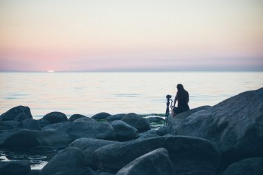 kayalık plaj fotoğrafçı ile gün batımında. Retro grenli film bak.