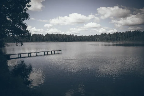 Reflejos en el lago con paseo marítimo. Aspecto de película granulada retro . — Foto de Stock