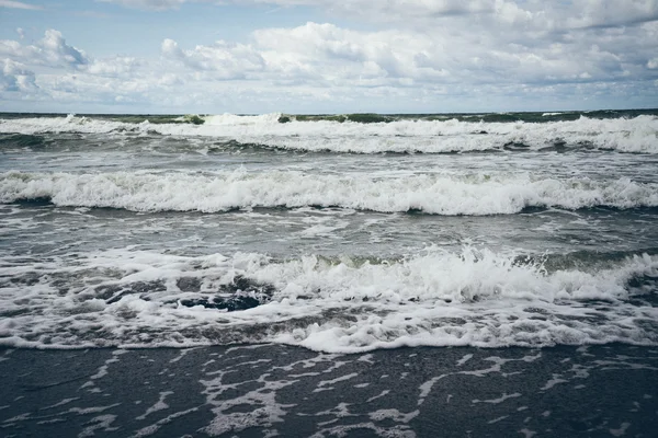 Olas de agua corriendo en la arena. Aspecto de película granulada retro . — Foto de Stock