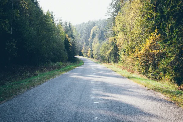 Wet asphalt road with sun reflections. Retro grainy film look. — Stock Photo, Image