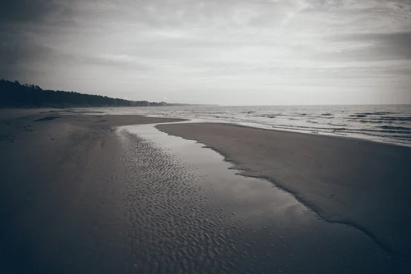 Shoreline of Baltic sea beach with rocks and sand dunes. Retro g — Stock Photo, Image