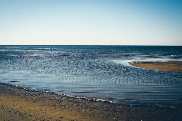 Praia do mar gelada com os primeiros pedaços de gelo. Retro olhar filme granulado . — Fotografia de Stock
