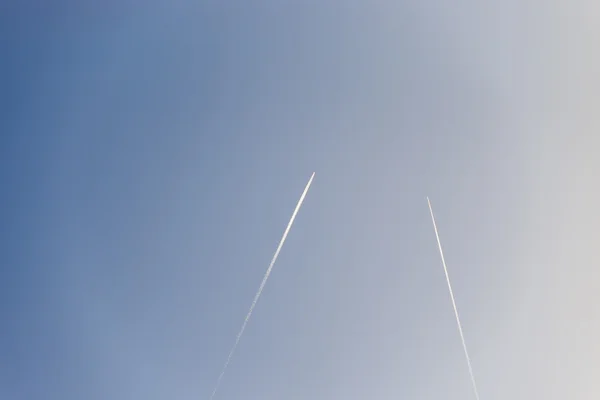 L'aereo vola basso nel cielo, lasciando una scia bianca — Foto Stock