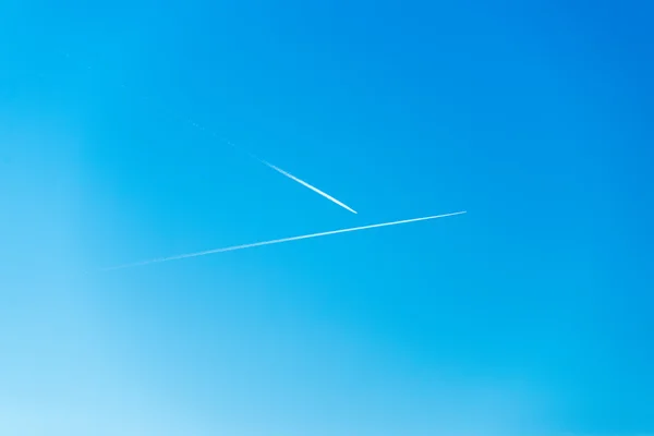 The plane flies low in the sky, leaving a white trail — Stock Photo, Image