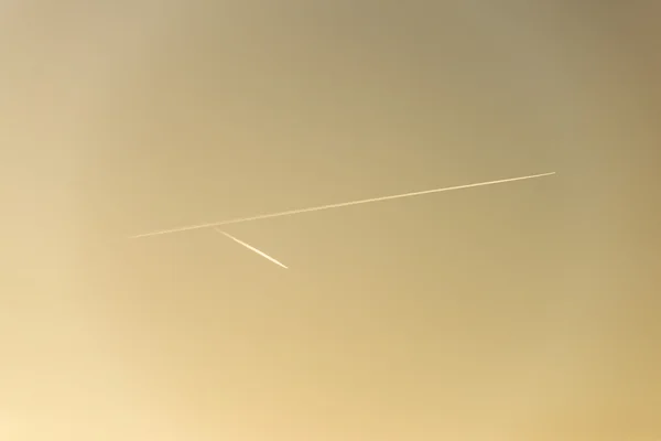 El avión vuela bajo en el cielo, dejando un rastro blanco — Foto de Stock