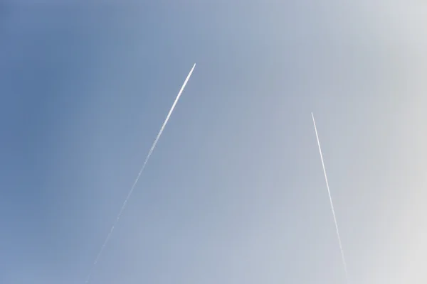 El avión vuela bajo en el cielo, dejando un rastro blanco — Foto de Stock