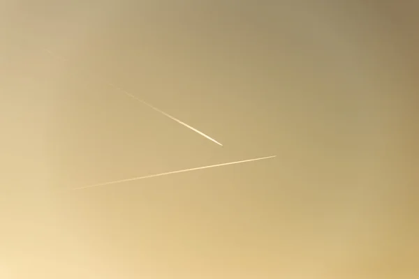 El avión vuela bajo en el cielo, dejando un rastro blanco — Foto de Stock