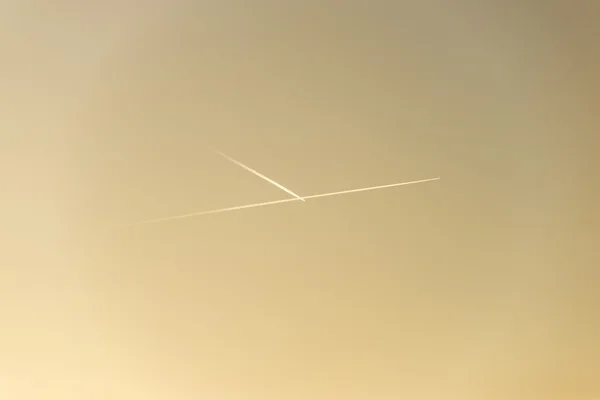 El avión vuela bajo en el cielo, dejando un rastro blanco — Foto de Stock