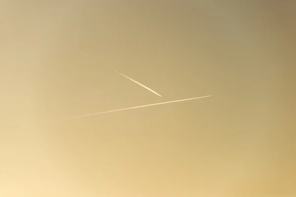 El avión vuela bajo en el cielo, dejando un rastro blanco — Foto de Stock