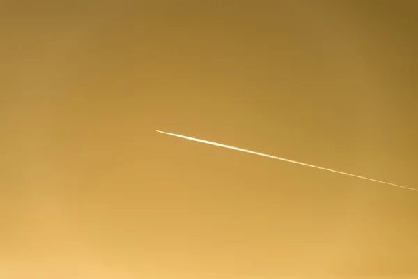 El avión vuela bajo en el cielo, dejando un rastro blanco — Foto de Stock