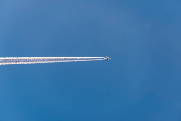 El avión vuela bajo en el cielo, dejando un rastro blanco — Foto de Stock