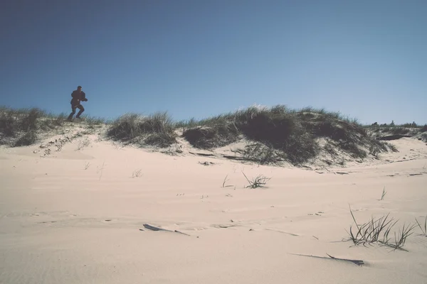 Man lopen in de duinen door de zee - retro, vintage — Stockfoto